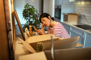 Woman unpacking boxes and organizing kitchen after moving into new home