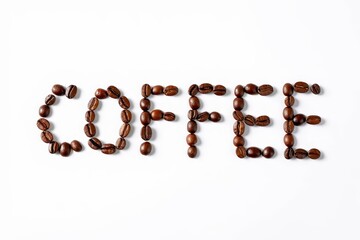 Top view of the word coffee written with coffee beans on white background with space for text.
