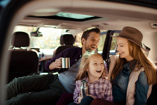 Family road trip enjoying hot drinks in the back of SUV