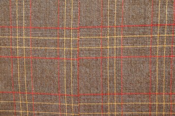 This detailed image showcases a brown plaid fabric, ideal for textures and backgrounds.
