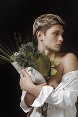 Stylish Young Man Holding A Greenery Bouquet Against Dark Background 