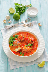 fish cakes in tomato vegetable coconut milk sauce