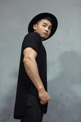 Stylish Young Asian Man Standing in Black Outfit and Fashion Hat