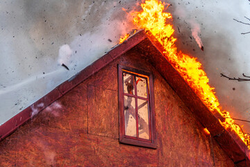 fBurning roof of residential house during fire