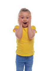 A cheerful young girl in a yellow shirt and jeans stands against a white background with a joyful...