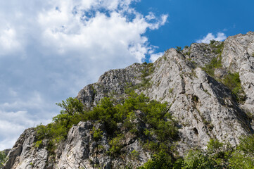 Limestone cliffs of Turda Gorge in Romania under blue sky with scattered clouds