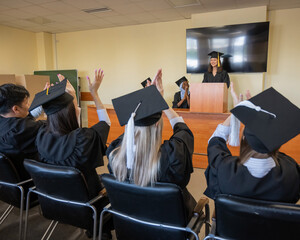 A young woman stands at the lectern and delivers a graduation speech to her classmates. 