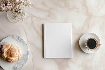 Blank white magazine on marble table with coffee cup on white saucer and bread on plate. Flat lay photography with natural flowers on light background. Breakfast and leisure concept.