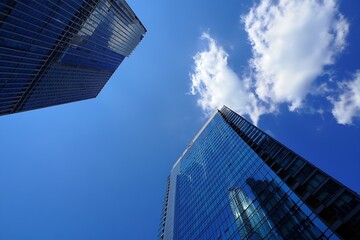 Modern Glass Towers Reaching Towards a Bright Blue Sky with Wispy Clouds