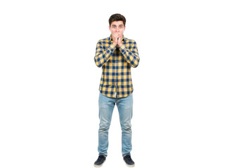 A young man with brown hair and blue eyes, wearing a plaid shirt and jeans, covering his mouth with his hands in shock isolated on a transparent background