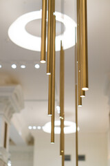 Modern elongated gold lamps in a bright room