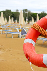 Lifebuoy in Focus with Umbrellas in Background
