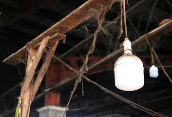An abandoned and neglected ceiling with dirty old light bulbs covered in thick spider webs and...