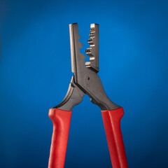 Specialized crimping pliers for electrical cable ends on blue gradient background