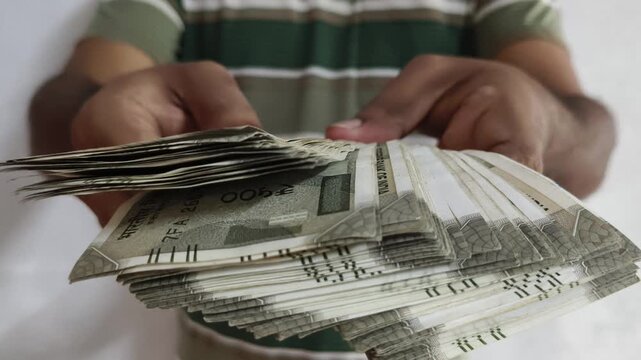 India rupee currency or indian money closeup. adult person hand offering banknote towards camera. Sharing, charity, donation, support, compassion, humanity and community help concept.