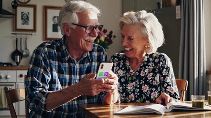 An older couple sitting at table with phone. Elderly couple talking on the phone on smartphone. Kitchen with a table and chairs and a table for leisure. An elderly pair at a table with a lifestyle.