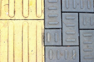 A yellow foot path sign for guiding block for the blind. A disability access path installed on the...