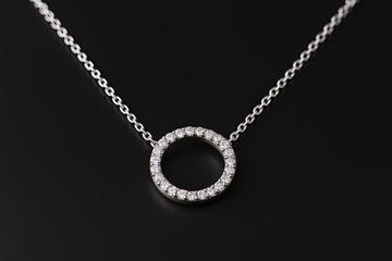 Elegant silver circle pendant necklace adorned with sparkling gemstones on fine chain.