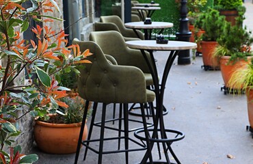 High bar tables and chairs on the open veranda of the restaurant