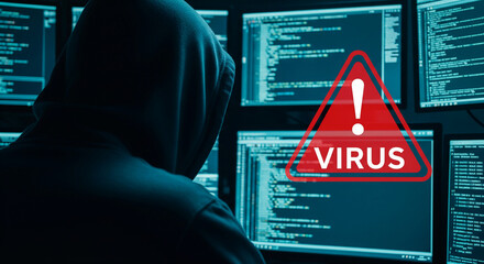 Hooded figure sits before multiple computer screens displaying code, a red virus warning overlayed, symbolizing cyber threat, digital security risk