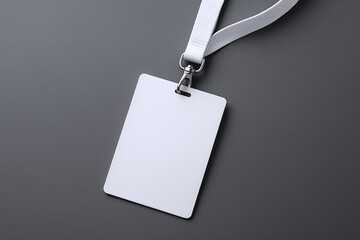 Minimalist blank white identification badge with lanyard on gray background.