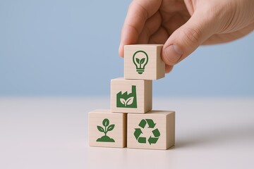Hand placing wooden blocks with eco friendly symbols on gray background.