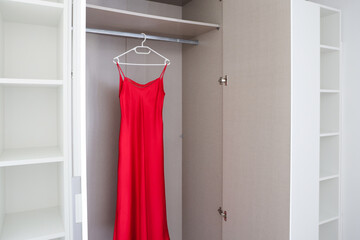 Red Dress Hanging in Open Wardrobe with Shelves
