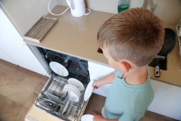 Child Puts Plates into Dishwasher