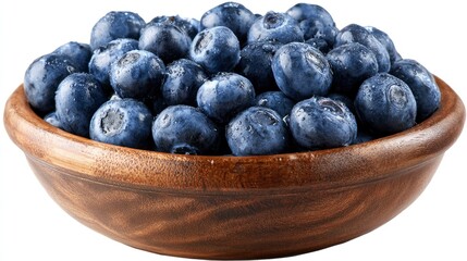Fresh ripe blueberries glistening with water droplets are piled high in a wooden bowl on white.