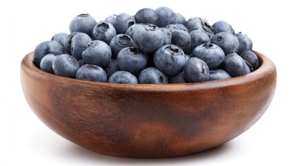A wooden bowl filled with fresh ripe blueberries sits on a white surface, delicious treat