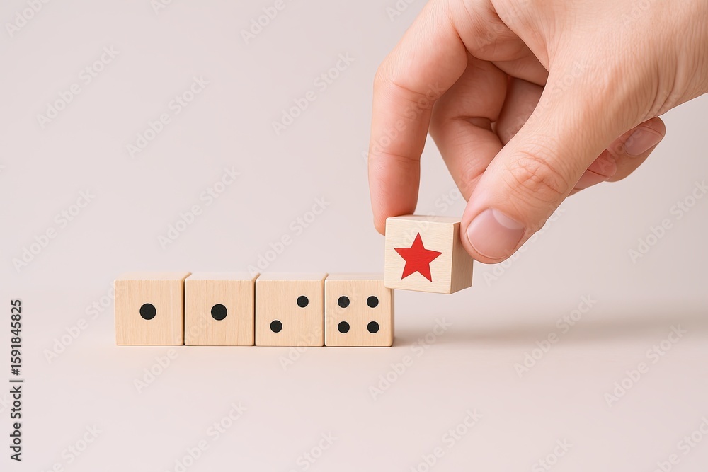 Aufkleber hand placing a wooden block with red star into row of dices on plain background.