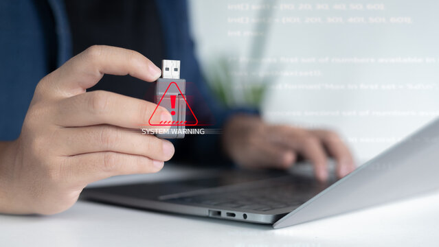 Close-up hand plugging USB with system warning alert, cybersecurity threat, malware infection risk, data breach prevention concept in digital workplace. - Powered by Adobe