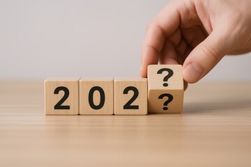 Hand placing wooden block on the line of year blocks symbolizing future planning.