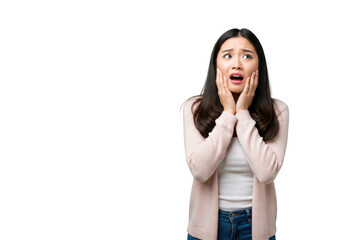 A young asian woman sits crosslegged on a transparent background, holding her face in fear with hands on her cheeks