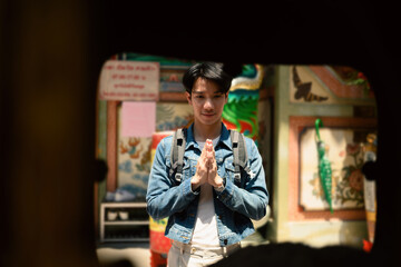 A cultural travel moment as an Asian man pays homage at a traditional Chinese shrine