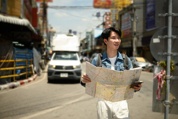 Discovering Chiangmai, an Asian backpacker looks for directions on a sunny day