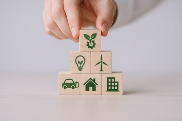 Hand stacking wooden blocks with eco friendly icons representing sustainability energy and environment.