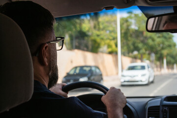 Man driving minivan concentrating on road following another car