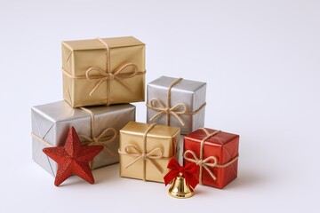 Obraz premium Festive Holiday Gift Boxes Wrapped in Silver and Gold with Red Star and Bell.