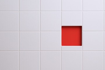 Minimalist white tiled wall with one red square inset for modern interior design.