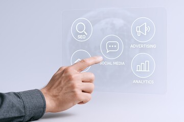 Businessman interacting with transparent digital interface showing social media marketing and analytics icons.