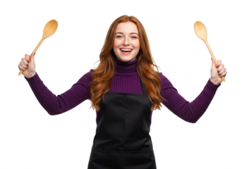 A cheerful redhead woman wearing an apron holds wooden spoons, isolated on a transparent background