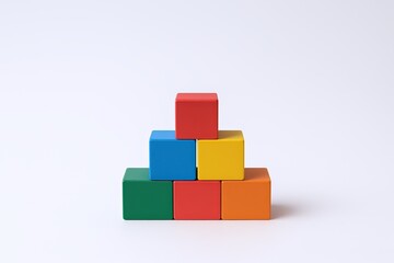 Colorful Wooden Building Blocks Arranged in a Pyramid Shape on White Background.