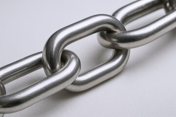 Obraz premium Close-up of shiny metal chain links interconnected, representing strength and connection.