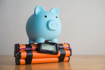 Piggy and with time bomb on wooden table. Concept of personal financial problem, high inflation, recession crisis, risk and savings management, loss investment, expenses overburden, installment.