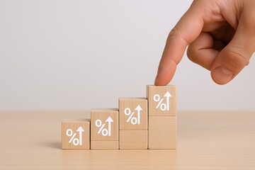 Hand pointing at increasing wooden blocks with percentage symbols symbolizing growth.