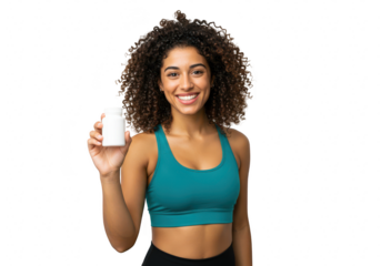 A happy young woman with curly hair in a sports bra holds a white bottle of supplements isolated on transparent background