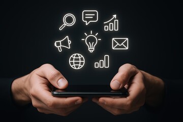 Digital marketing and social media icons floating above hands holding smartphone on black background.