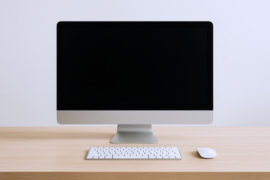 Modern desktop computer with large screen monitor keyboard and mouse on wooden table.