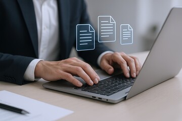 Business professional working on laptop with digital document icons floating above workspace.